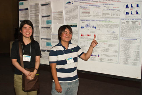 Two students in front of a poster