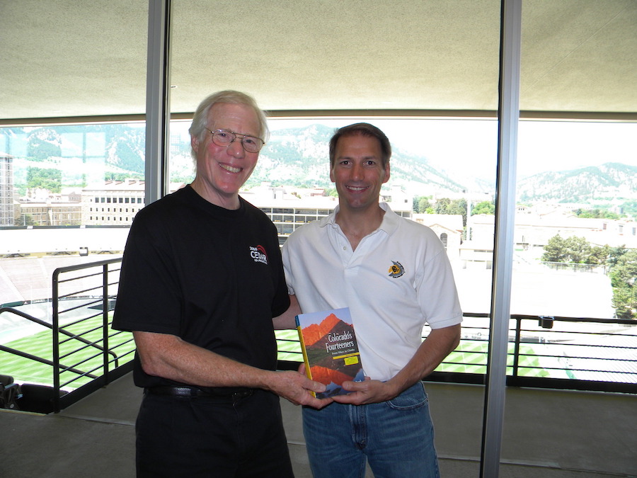 John Foster (MIT) the new CEDAR chair gives a book to the retiring chair Jeff Thayer (U CO) on climbing Colorado mountain peaks in the stadium club area where the poster sessions were held