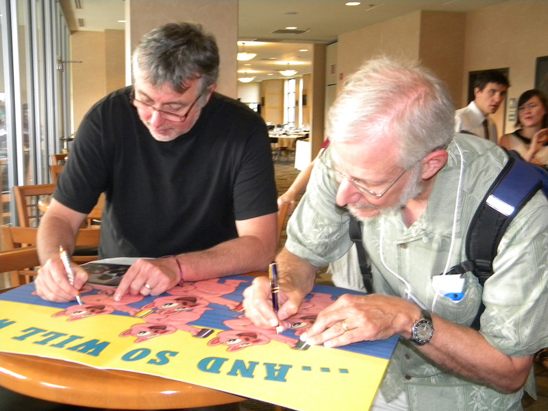 Eric Donovan (U Calgary, chair of GEM) and Jeremy Winick (retired from AFRL) sign a big 'Farewell' retirement card for Louise Beierle who manned the registration desk and helped organize the CEDAR Worskhop for 20 years from the first workshop in 1986 to 2005.