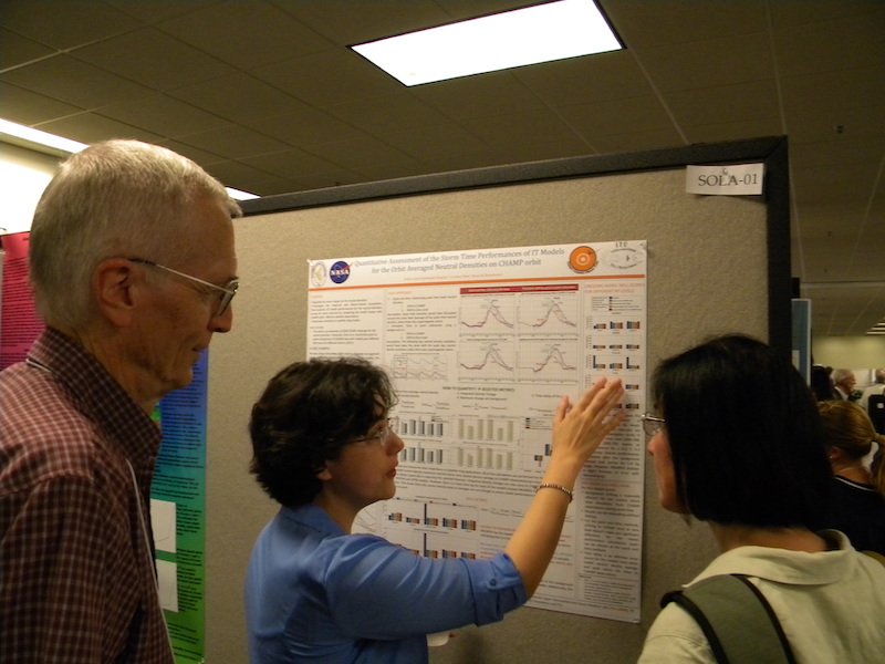 Ceren Kalafatoglu (Turkish student at the CCMC) at her poster SOLA-01 with Art Richmond (NCAR) and Cheryl Huang (AFRL, back to camera) in one of the poster areas.