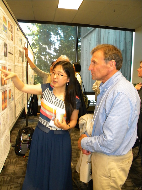 Boyi Wang (UCLA) explains her poster SOLA-20 to Evgeny Mishin (AFRL).